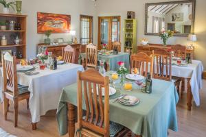 a dining room with tables and chairs and a mirror at Mirihof Retreat and Olive Estate in Montagu