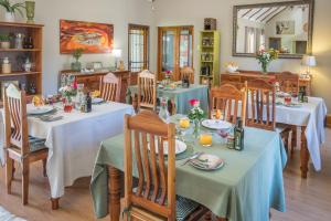 comedor con mesas, sillas y espejo en Mirihof Retreat and Olive Estate, en Montagu