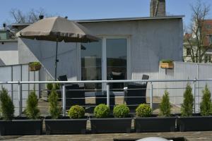 a patio with an umbrella and chairs and a fence at Pension am Schloss in Schwerin