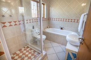 a bathroom with a tub and a toilet and a sink at Mirihof Retreat and Olive Estate in Montagu