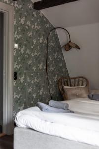 1 dormitorio con 1 cama con papel pintado de flores en Trädgårdsmästarbostaden / The Gardeners Villa, en Gävle