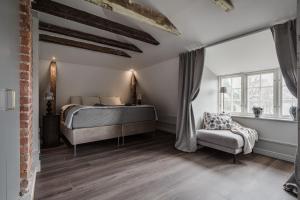 1 dormitorio con 1 cama y 1 silla en Trädgårdsmästarbostaden / The Gardeners Villa, en Gävle