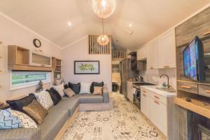 a living room with a couch and a tv at Oak Tree View in Nantmel