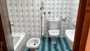 a bathroom with a toilet and a tub and a sink at Casa Tere Panticosa in Panticosa