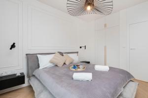 a bedroom with a bed with a tray of food on it at Gdańsk Tarasy Bałtyku by Renters Prestige in Gdańsk
