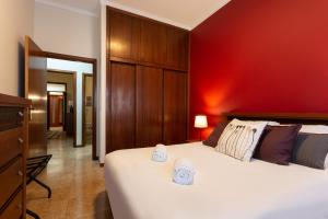 sypialnia z dużym łóżkiem z czerwoną ścianą w obiekcie Porto Residence Campanhã w Porto
