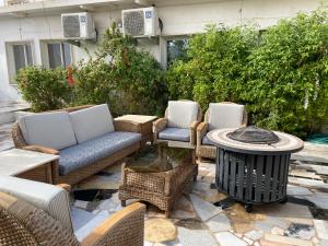 patio z wiklinowymi meblami, stołem i krzesłami w obiekcie سمو1 w Rijadzie