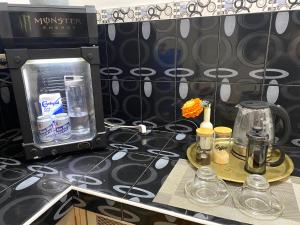 a counter with a coffee maker and glasses on it at CoG BnB Lubao -100 Mbps WiFi in Lubao