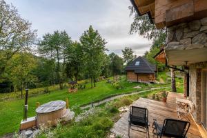een achtertuin met een hot tub en een houten terras bij Osada Sudecka in Lądek-Zdrój