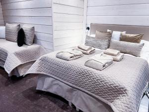 un grande letto con cuscini sopra in una camera da letto di Santa's Luxury Boutique Villa, Santa Claus Village, Apt 1 a Rovaniemi