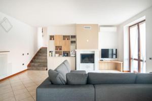 un soggiorno con divano blu e TV di Villa Vista Lago di Como by villavistalago a Bellano