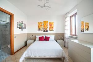 una camera da letto con un letto bianco con cuscini rossi di Villa Vista Lago di Como by villavistalago a Bellano