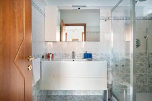 bagno con lavandino bianco e doccia di Villa Vista Lago di Como by villavistalago a Bellano