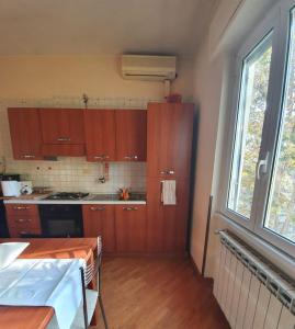 una pequeña cocina con armarios de madera y una ventana en Ferrari House en Roma