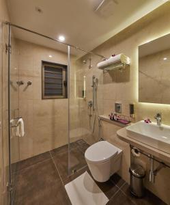 a bathroom with a shower and a toilet and a sink at Regenta Inn Grand-ORR, Mahadevapura in Bangalore
