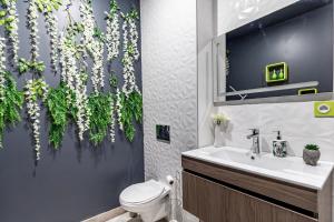 bagno con servizi igienici e lavandino con piante di Sweet Uni'vert Jacuzzi a Le Breuil