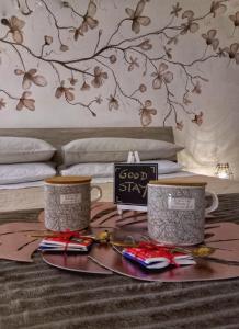 a tray with two coffee mugs on a bed at Dimora Santa Caterina in Altamura