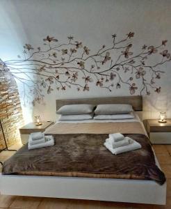 a bedroom with a bed with a tree mural on the wall at Dimora Santa Caterina in Altamura