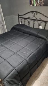 ein schwarzes Bett mit einer schwarzen Decke drauf in der Unterkunft IL COLOSSEO B&B CASSINO in Cassino