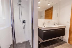 a bathroom with a sink and a shower at Chalet Hohe Tauern - Steinbock Lodges in Zell am See