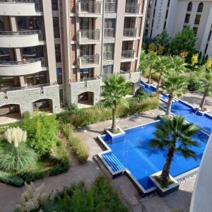 Una vista aérea de un edificio con piscina y palmeras. en La Perla Cascadas, en Sunny Beach