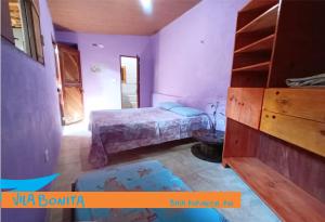 a small bedroom with a bed and a dresser at Casinhas Vila Bonita Hobbit in Baía Formosa