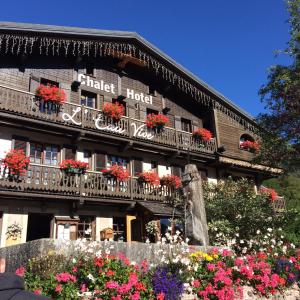 un hôtel avec des fleurs devant un bâtiment dans l'établissement Chalet Appart'Hôtel l'Eau Vive, à Saint-Nicolas-la-Chapelle