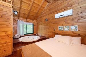een slaapkamer met een bed en een bad bij Nof Kineret Suites in Moshav Ramot