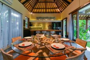 a dining room with a wooden table and chairs at Villa Intan in Legian
