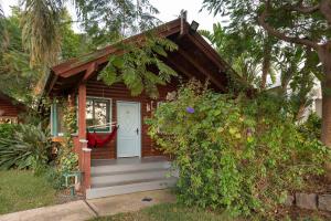 Casa pequeña con porche y puerta blanca en Nof Kineret Suites en Moshav Ramot
