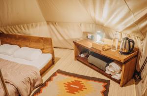 a room with a bed and a table in a tent at Alamu Eco Lodge in Bedugul