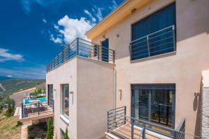 una casa con balcones a un lado en The Dynasty Villas, en Sivota