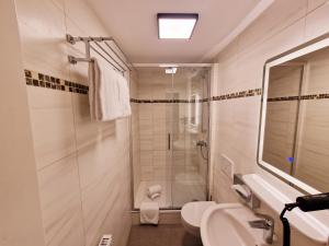 a bathroom with a shower and a toilet and a sink at Sophien Hotel in Frankfurt/Main