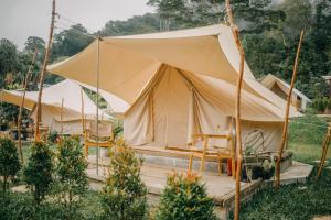 a large tent with chairs in a garden at Alamu Eco Lodge in Bedugul