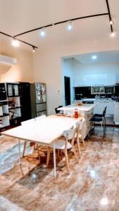 eine große Küche mit einem großen weißen Tisch und Stühlen in der Unterkunft Home is Love house Homestay in Chaozhou
