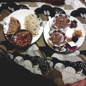 a table with plates of food and bowls of rice at Karina art Home stay in Bikaner