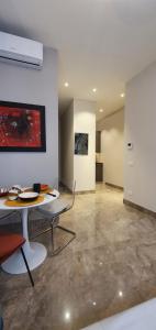 a room with a table and chairs and a painting at Pink Maison Milano Centro Piazza Diaz Duomo in Milan +21 photos