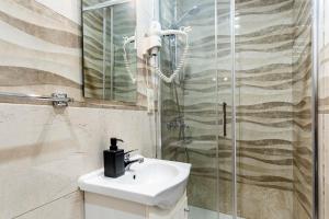 uma casa de banho com um lavatório e um chuveiro em Hostal Rincón de Sol em Madri