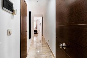 マドリードにあるHostal Rincón de Sol - Centro Madrid - Self Checkinの木製のドア付きの廊下、リビングルーム付きの廊下