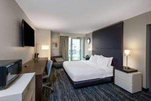 a hotel room with a bed and a flat screen tv at 41 Lakefront Hotel, Trademark Collection by Wyndham in Geneva