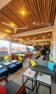 a lobby with couches and tables in a building at THE PLACE Hostel & Rooftop Bar in Battambang