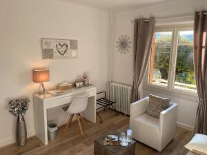 a living room with a desk and a chair at B&B Le Saut de la Bergère in Aubazines