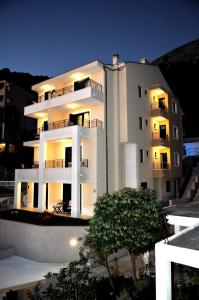 a large white building with its lights on at Apartments Villa Tomislav in Brela