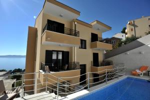 a building with a swimming pool in front of it at Apartments Villa Tomislav in Brela