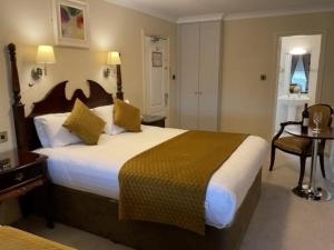 ein Hotelzimmer mit einem großen Bett und einem Tisch in der Unterkunft Atlantic Hotel in Lahinch