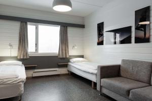 a room with a bed and a couch and a chair at Olympiatoppen Sportshotel - Scandic Partner in Oslo
