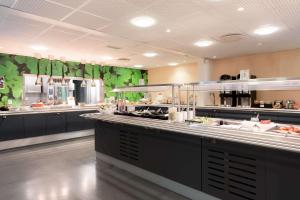 a restaurant kitchen with a buffet line with food at Olympiatoppen Sportshotel - Scandic Partner in Oslo