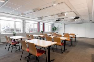 uma sala de aula com mesas e cadeiras numa sala em Olympiatoppen Sportshotel - Scandic Partner em Oslo