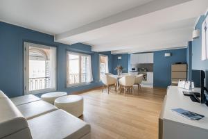 ein Wohnzimmer mit blauen Wänden sowie einem Tisch und Stühlen in der Unterkunft Urbanicooh Asinelli - Piazza Maggiore View in Bologna