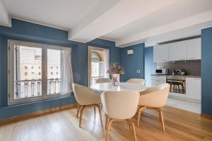 a dining room with blue walls and a table and chairs at Urbanicooh Asinelli - Balcony on Piazza Maggiore in Bologna
